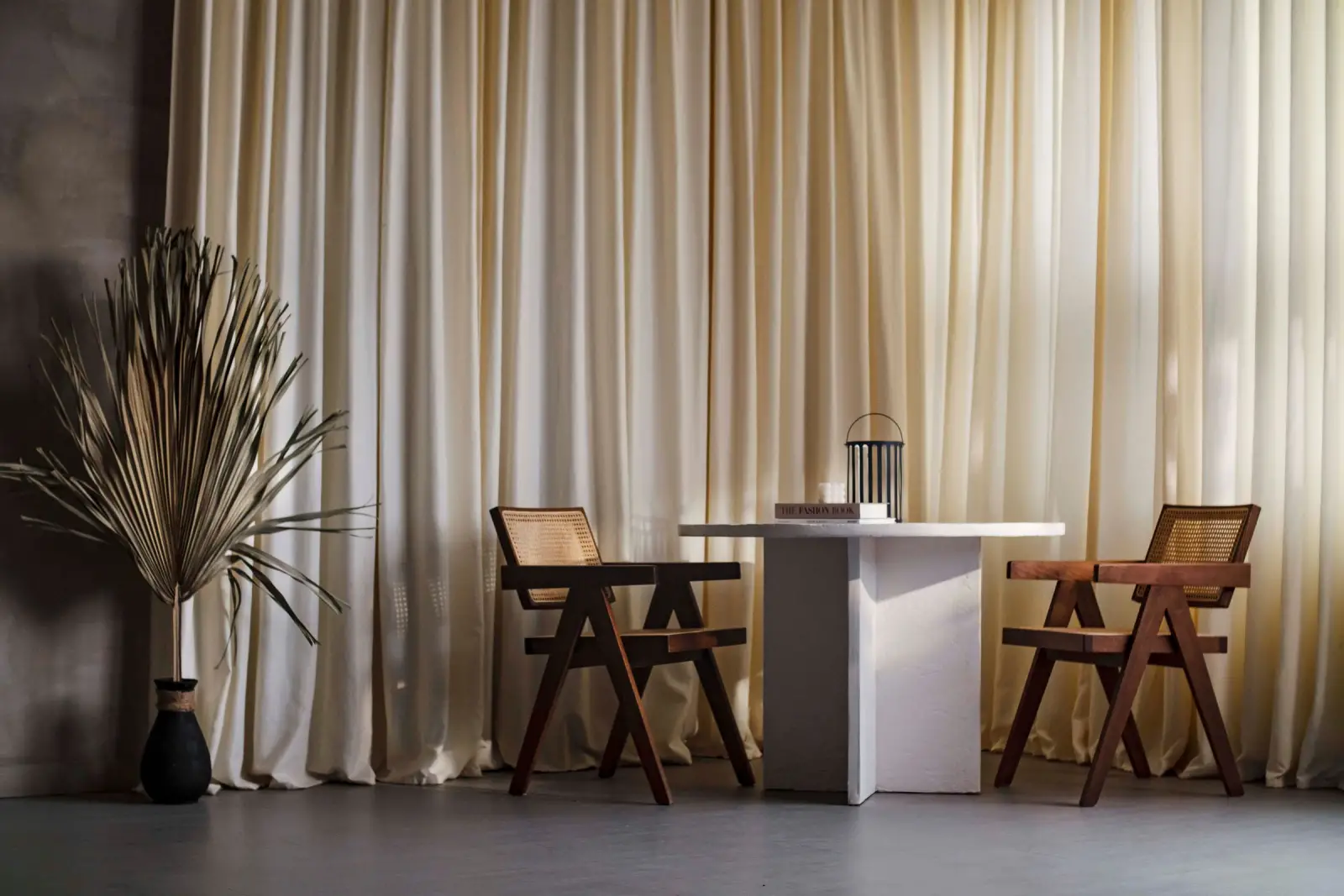 A quiet table for two beside linen curtains