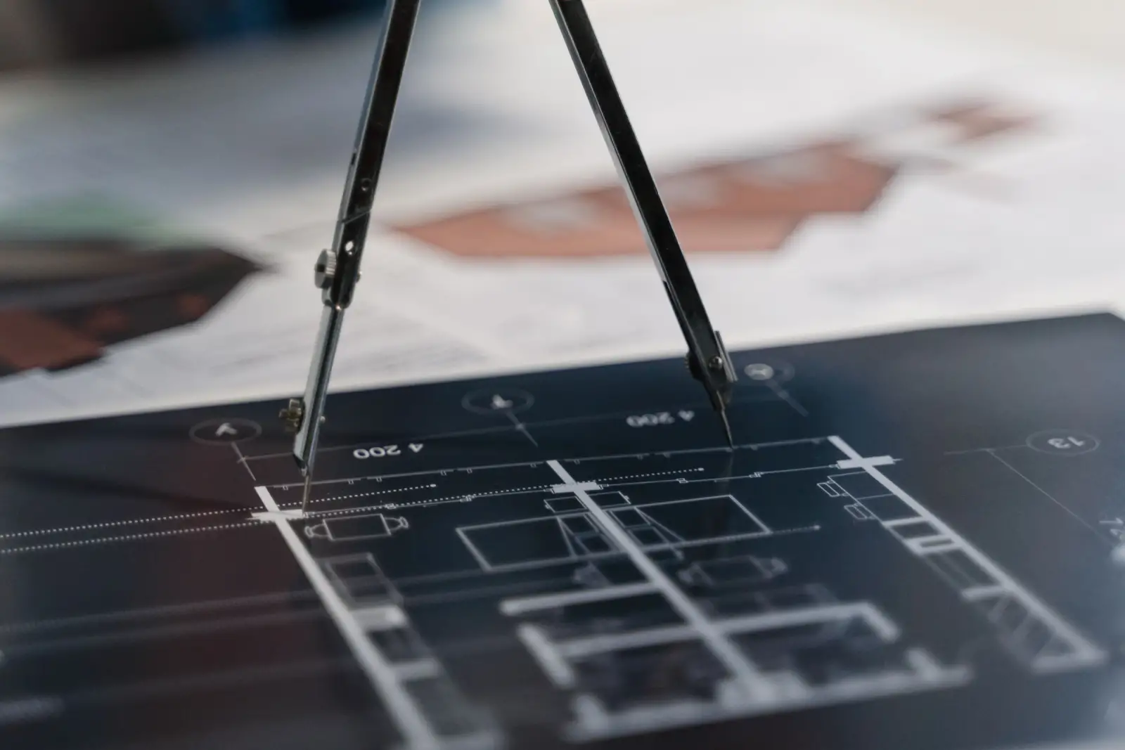 Compass measuring a dimensioned architectural plan